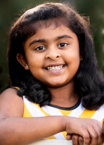 Happy young girl smiling brightly outdoors — healthy, natural smile